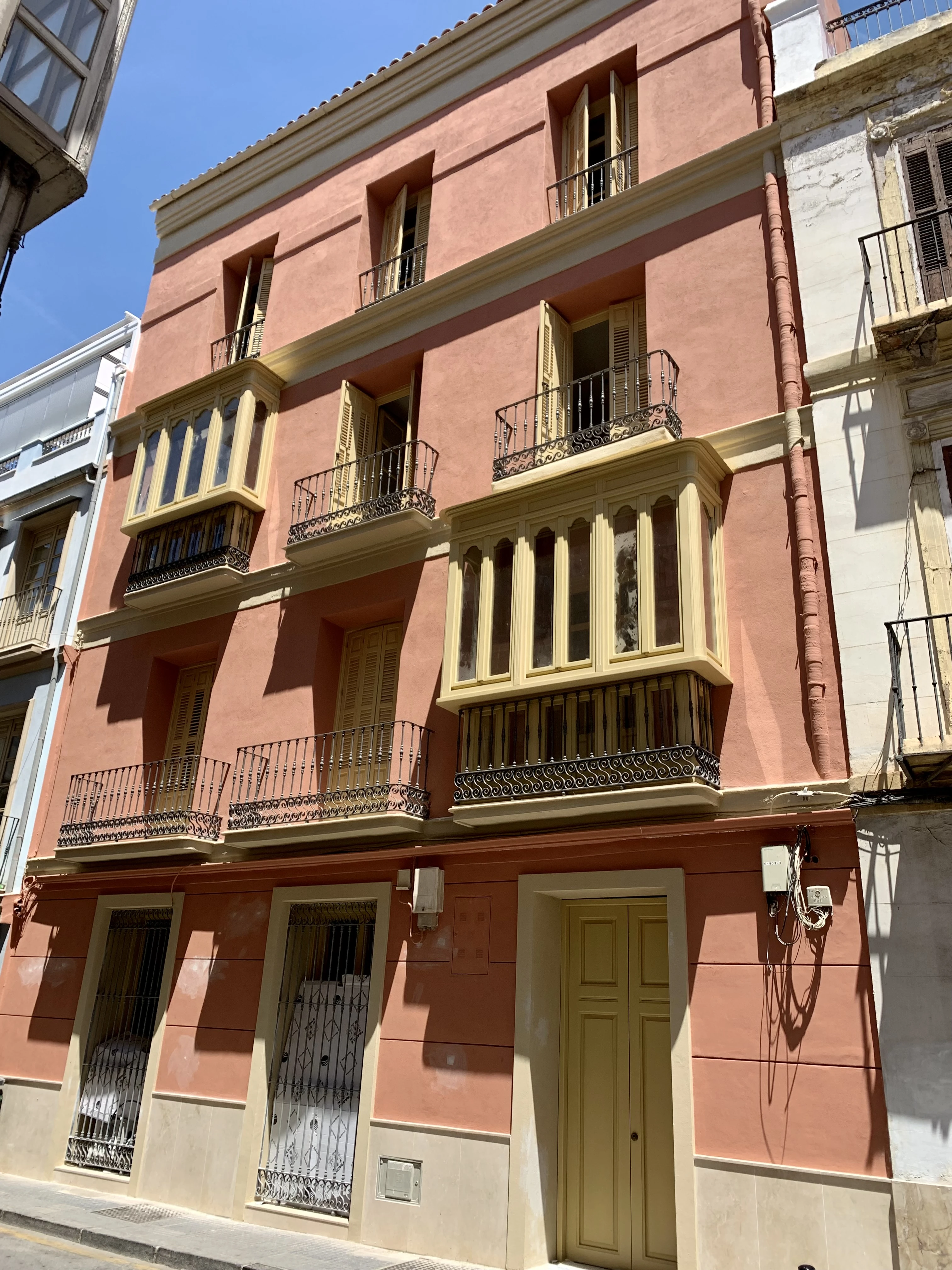 El Museo Apartamentos Málaga — fachada rehabilitada con balcones y contraventanas de madera