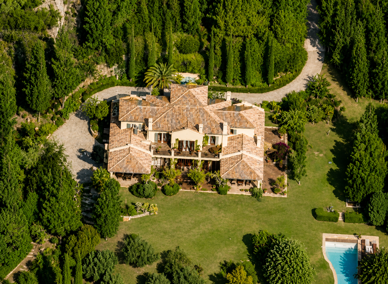 Vista aérea villa mediterránea con teja árabe, cipreses y piscina, Costa del Sol