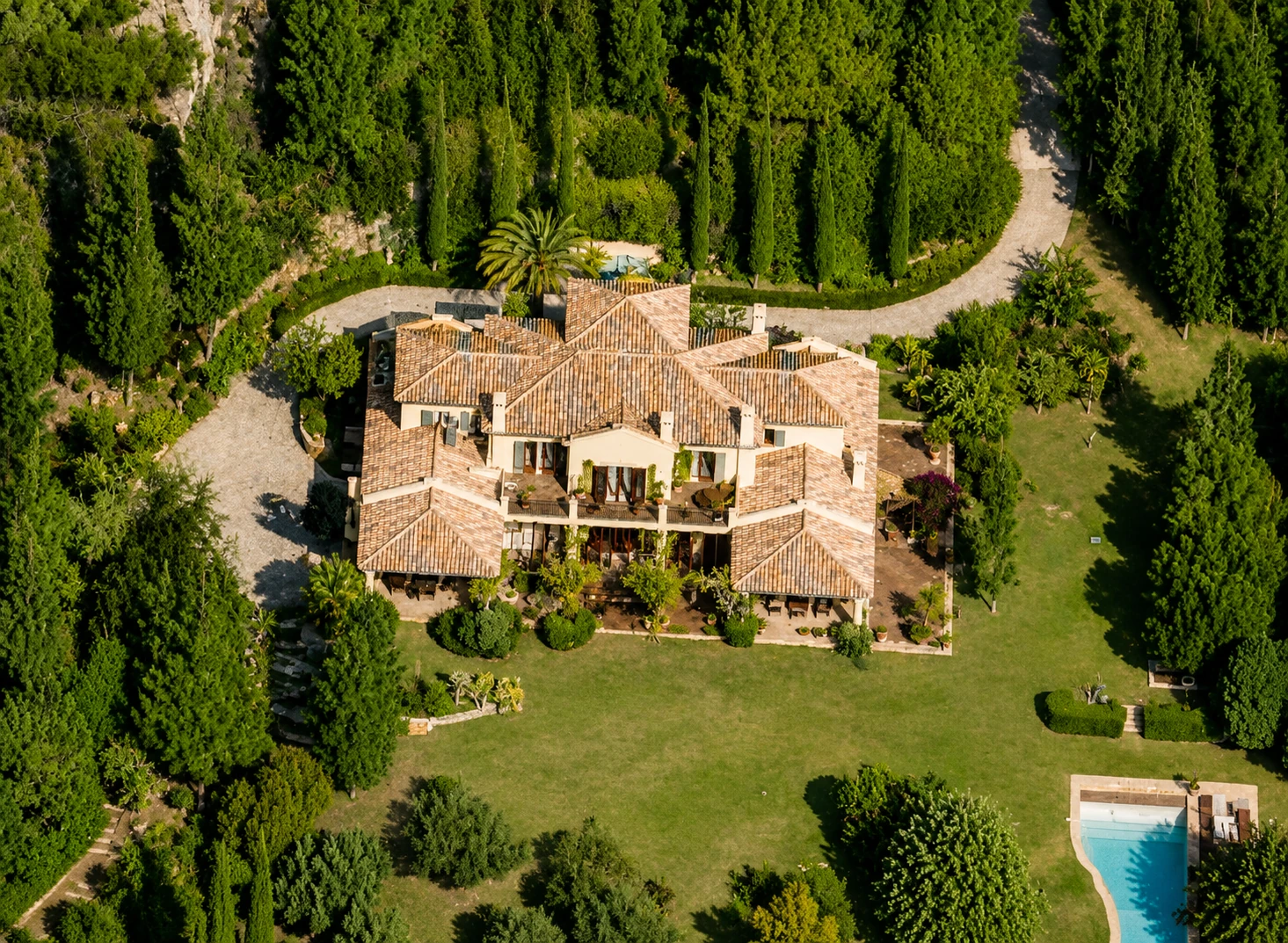 Vista aérea villa mediterránea con teja árabe, cipreses y piscina, Costa del Sol