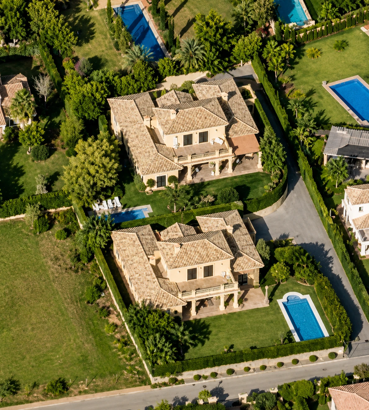 Vista aérea de villas mediterráneas pareadas con jardines y piscinas, Costa del Sol
