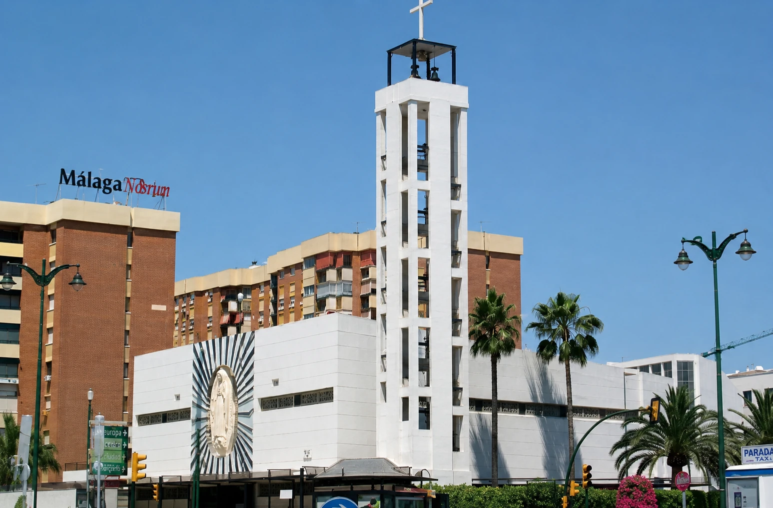 Iglesia de la Asunción de Nuestra Señora en la glorieta de Cruz de Humilladero, Málaga — fachada con torre y medallón escultórico de la Virgen