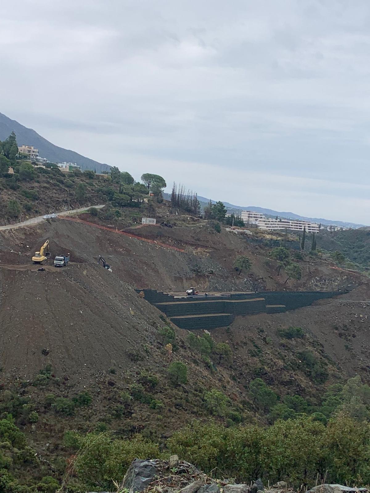 Excavadora trabajando en el desmonte de la ladera de El Madroñal durante los primeros meses de obra